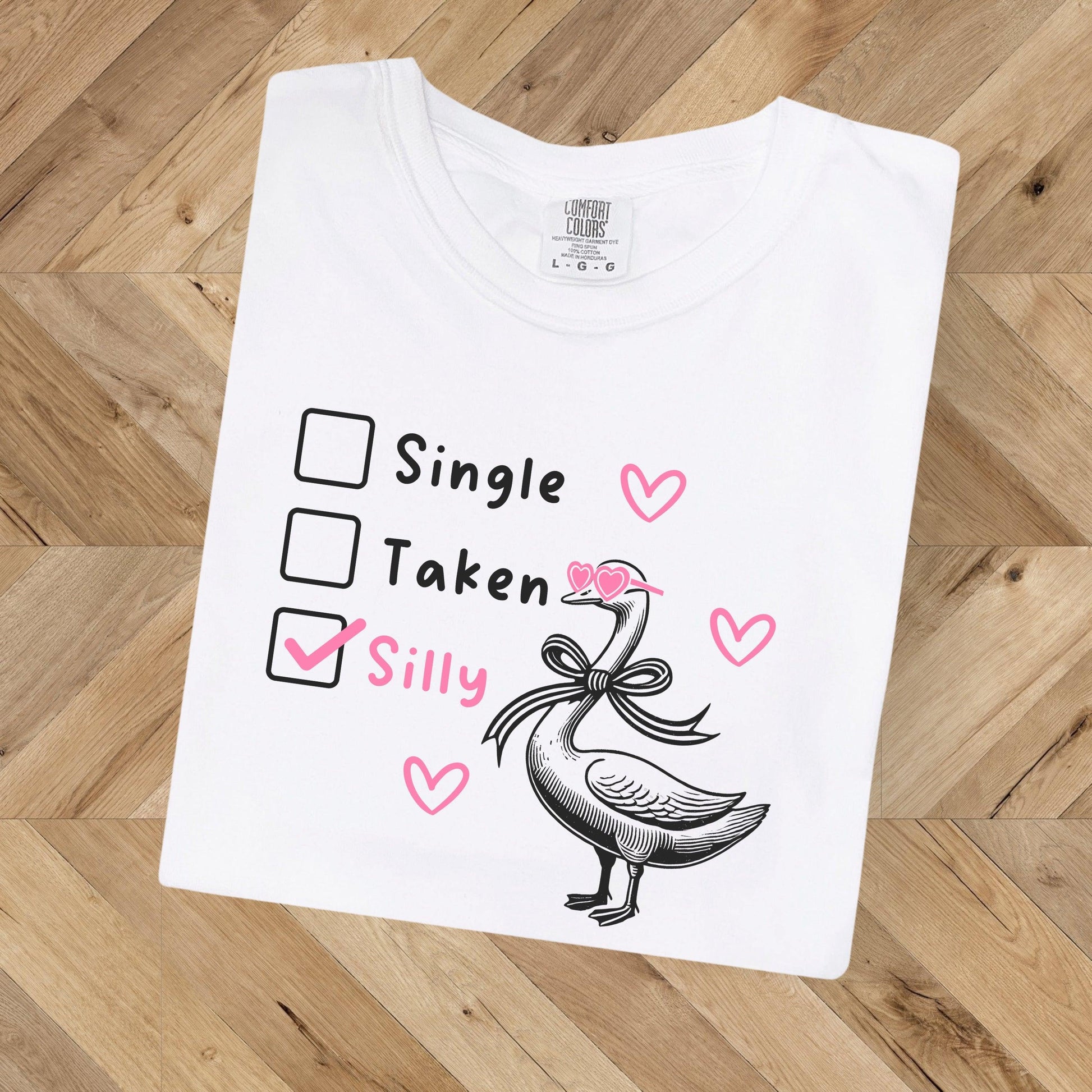Silly Goose Valentine's Day Shirt - Just Goofy Little Guys  T-Shirt Forget romance—it’s all about embracing your silly side this Valentine’s Day! Our “Single, Taken, Silly” tee features a playful design with checkboxes and the “silly” box proudly checked. Perfect for the goofy, fun-loving folks who prefer laughs over love songs. Made with soft Comfort Colors cotton, this unisex shirt is ideal for Valentine’s Day celebrations, Galentine’s hangouts, or just showing off your silly goose vibes all year round. 