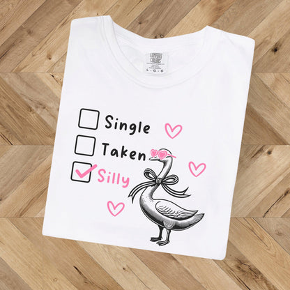 Silly Goose Valentine's Day Shirt - Just Goofy Little Guys  T-Shirt Forget romance—it’s all about embracing your silly side this Valentine’s Day! Our “Single, Taken, Silly” tee features a playful design with checkboxes and the “silly” box proudly checked. Perfect for the goofy, fun-loving folks who prefer laughs over love songs. Made with soft Comfort Colors cotton, this unisex shirt is ideal for Valentine’s Day celebrations, Galentine’s hangouts, or just showing off your silly goose vibes all year round. 