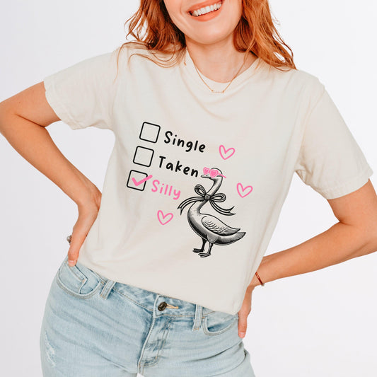 Silly Goose Valentine's Day Shirt - Just Goofy Little Guys  T-Shirt Forget romance—it’s all about embracing your silly side this Valentine’s Day! Our “Single, Taken, Silly” tee features a playful design with checkboxes and the “silly” box proudly checked. Perfect for the goofy, fun-loving folks who prefer laughs over love songs. Made with soft Comfort Colors cotton, this unisex shirt is ideal for Valentine’s Day celebrations, Galentine’s hangouts, or just showing off your silly goose vibes all year round. 